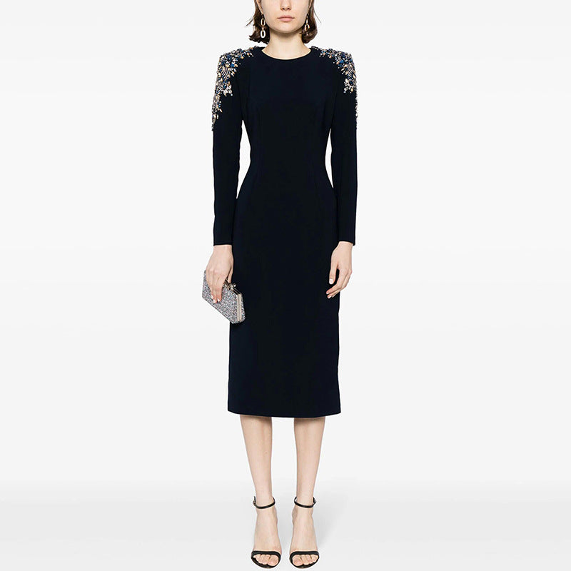 A mid-length, long-sleeved dress richly embellished with beads and rhinestones.