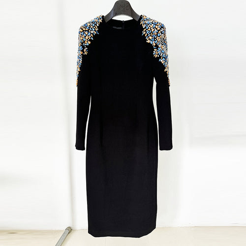 A mid-length, long-sleeved dress richly embellished with beads and rhinestones.