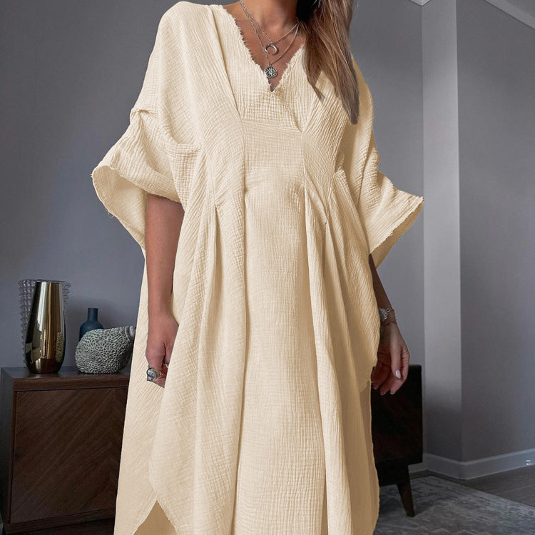 Crinkled fabric dress with a V-neck and long skirt; a loose, breathable dress.