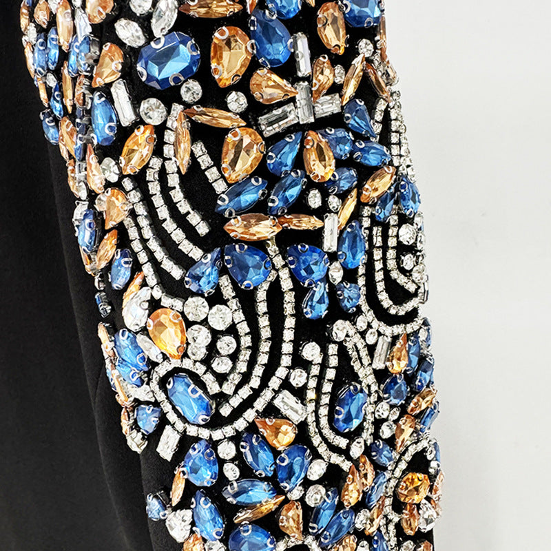 A mid-length, long-sleeved dress richly embellished with beads and rhinestones.