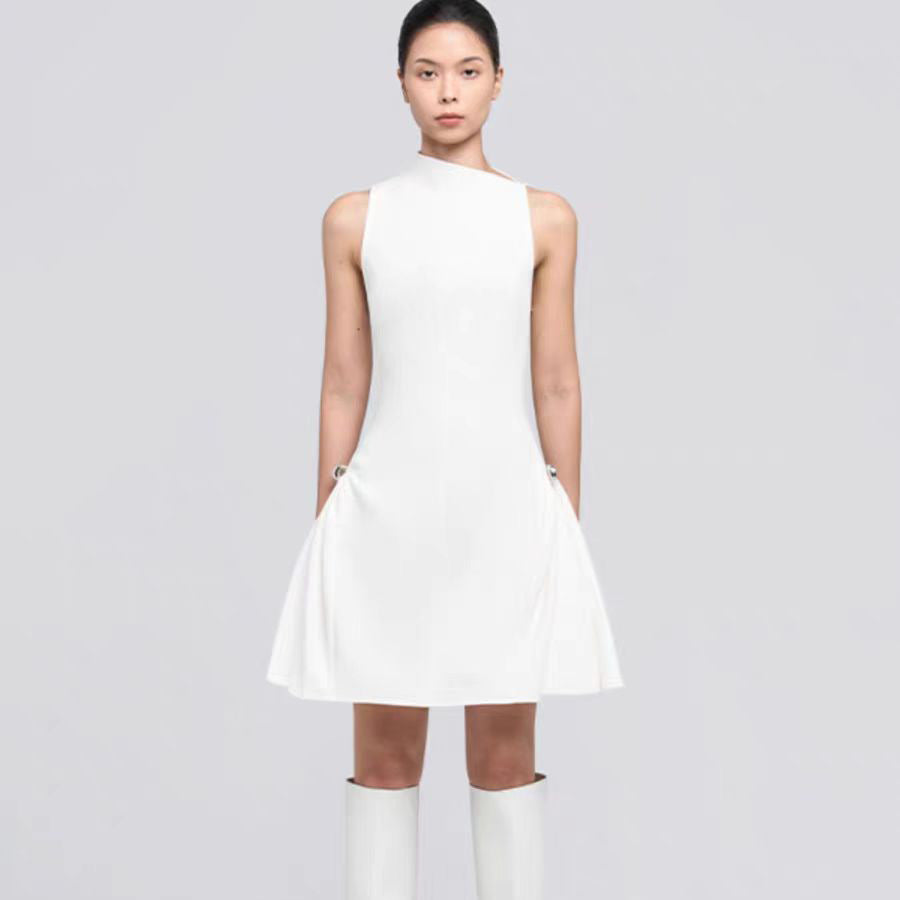A short, sleeveless dress featuring symmetrical pleats, a metal buckle, and a waist accent.