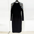 A mid-length, long-sleeved dress richly embellished with beads and rhinestones.