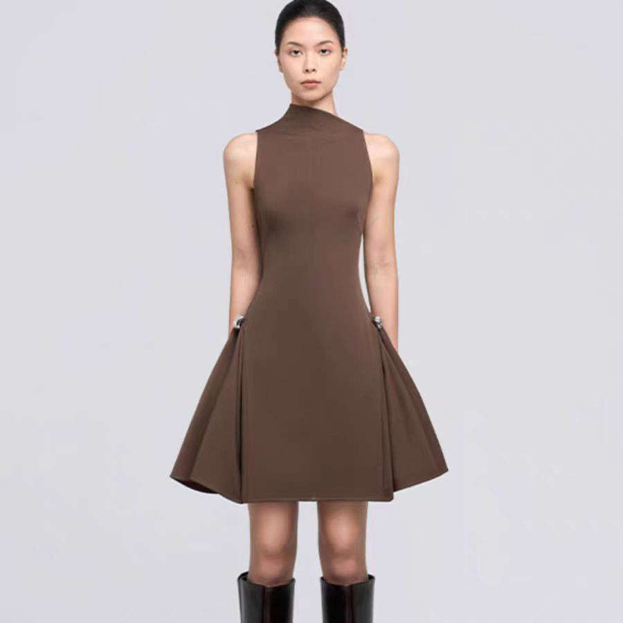 A short, sleeveless dress featuring symmetrical pleats, a metal buckle, and a waist accent.