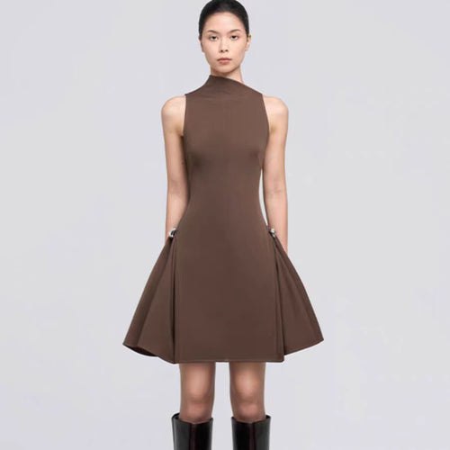 A short, sleeveless dress featuring symmetrical pleats, a metal buckle, and a waist accent.